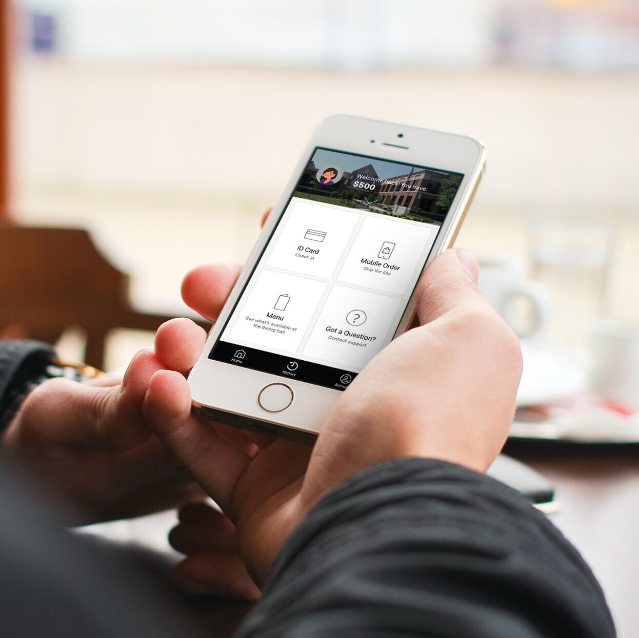 Hands holding a mobile phone in a dining setting